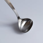 Close-up of Sori Yanagi Stainless Steel Ladle bowl highlighting smooth curves and brushed metal finish.