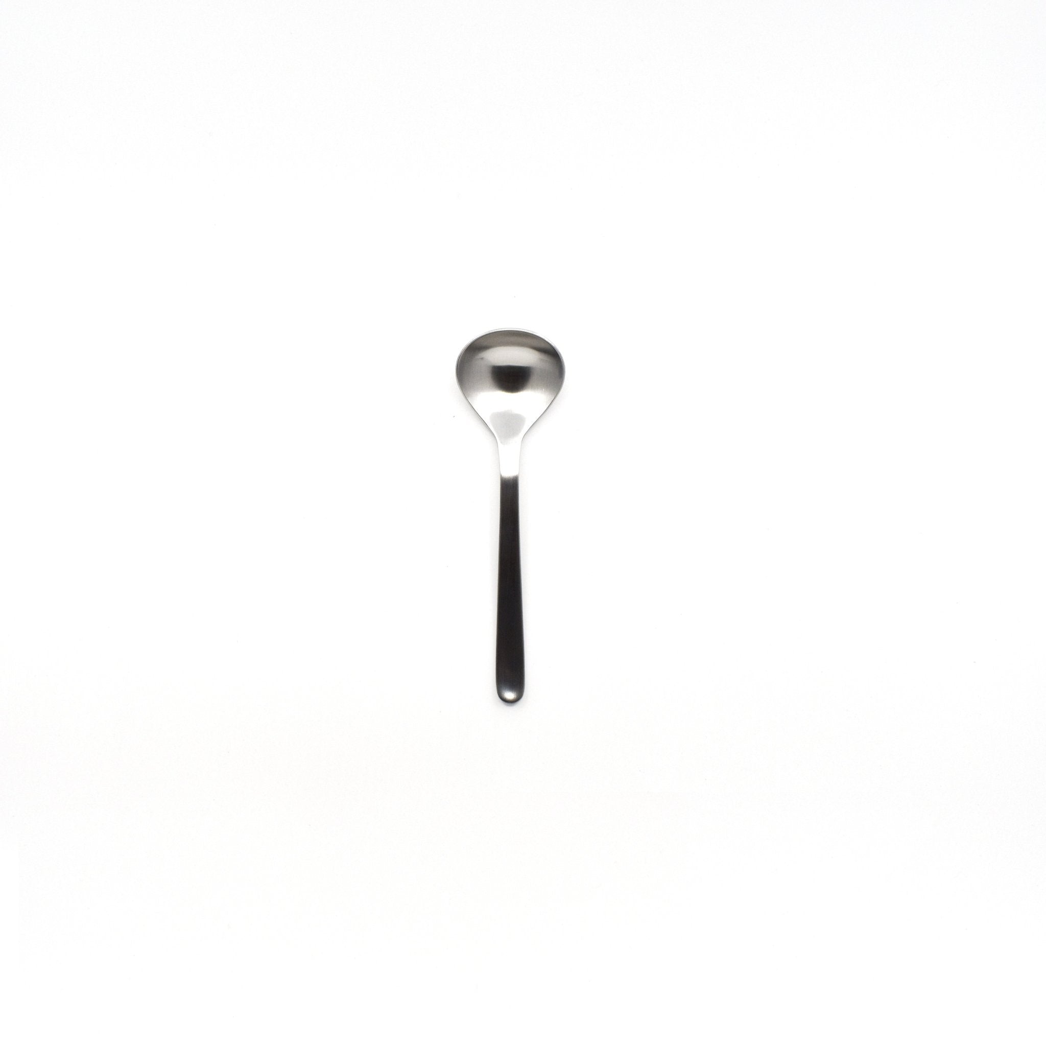 Sori Yanagi stainless steel soup spoon with a deep bowl and ergonomic handle, designed for smooth scooping and minimalistic modern aesthetics, photographed on a white background.