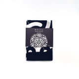 Folded Tokolo Musubi furoshiki cloth with indigo and white geometric wave pattern, wrapped in a minimalist black paper band with Japanese text and design preview.
