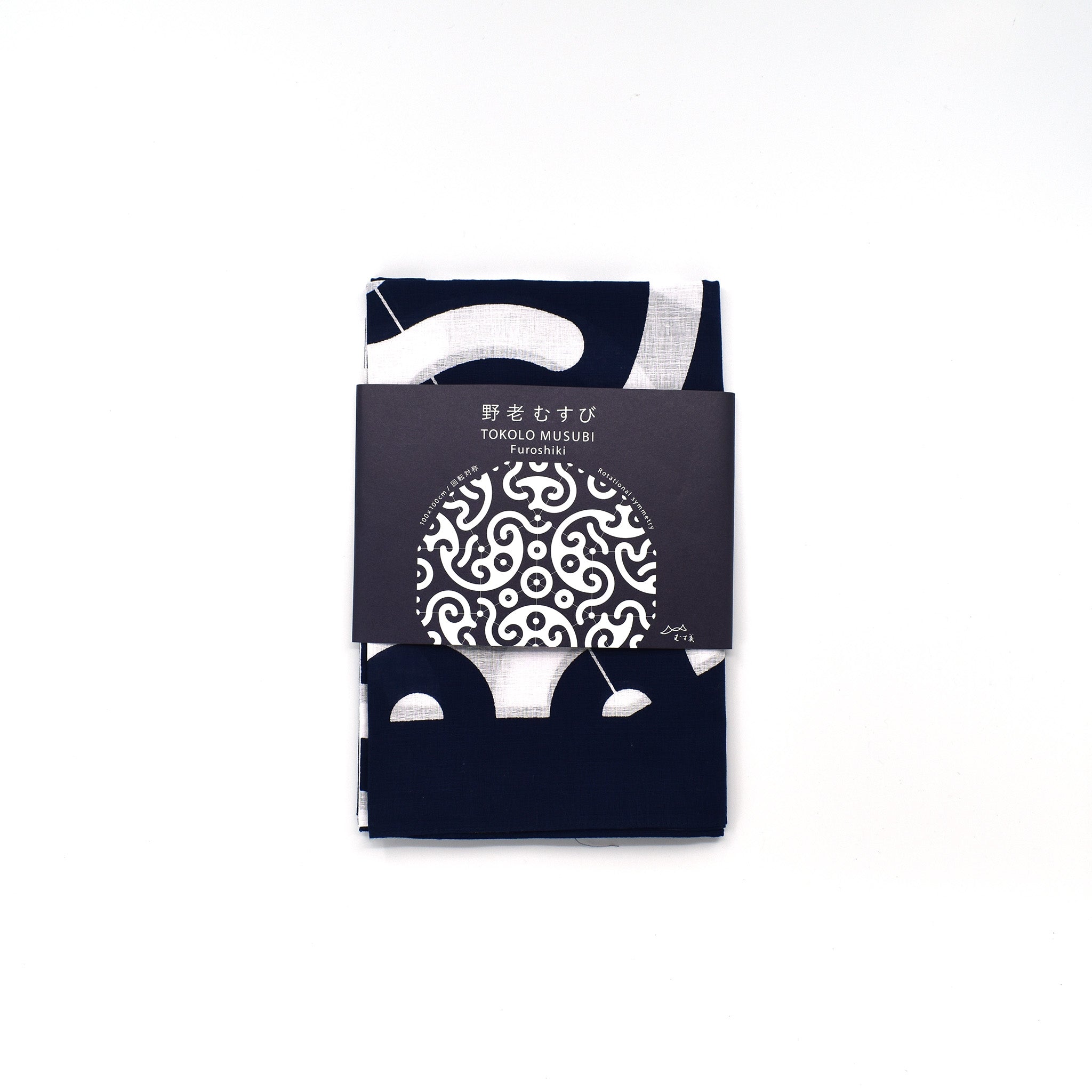 Folded Tokolo Musubi furoshiki cloth with indigo and white geometric wave pattern, wrapped in a minimalist black paper band with Japanese text and design preview.