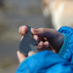 Close-up of a hand holding the Tosa Sperm Whale Knife, showcasing the unique whale-shaped design and matte black finish