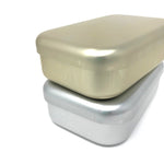 Stacked view of two rectangular aluminum bento lunch boxes in matte gold and silver finishes with rounded edges, displayed on a white background.