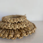 Close-up of three stacked handwoven Japanese straw pot mats showing detailed braided edges and natural fiber texture