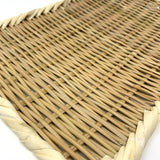Angled close-up of a handwoven rectangular bamboo zaru colander with a twisted rim, showcasing the fine basket weave and natural fiber texture on a white background