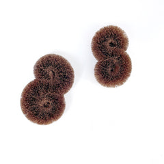 Overhead view of two pairs of brown circular tawashi scrubbers made from natural palm fibers, displayed on a white background.