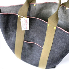 Close-up of redline selvedge Japanese denim tote showing the olive handles and pink selvedge detail.