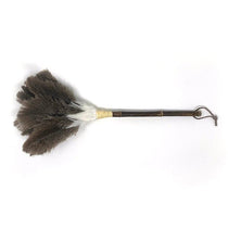 Feather duster with dark brown and white ostrich feathers, bamboo handle, and leather loop, placed on a white background