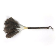 Feather duster with dark brown and white ostrich feathers, bamboo handle, and leather loop, placed on a white background