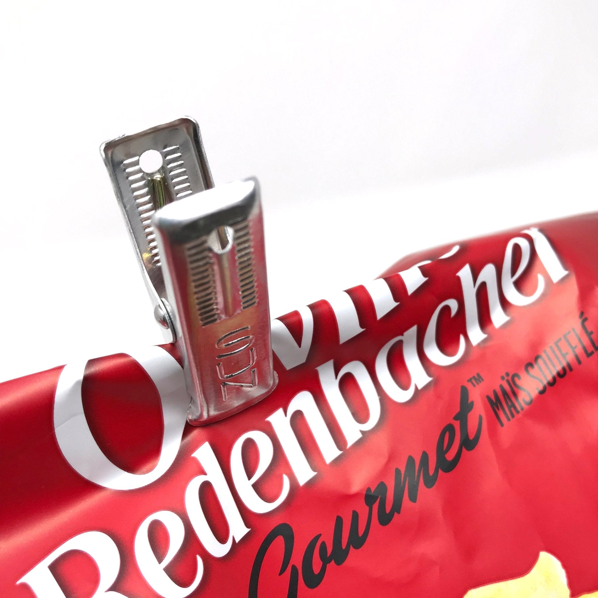 Close-up of a Japanese aluminum peg used as a chip bag clip, demonstrating its strong grip and versatility for everyday household use