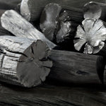Close-up of traditional Japanese Binchotan charcoal logs showing natural grain and high-purity finish.