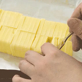 Looping gif showing a 5g slice being lifted from a pre-cut butter block using the Japanese butter slicer—ideal for precise portioning.