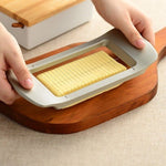 Japanese butter slicer being used on a wooden cutting board, effortlessly slicing a full block into even portions in a modern kitchen setting.