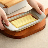 Japanese butter slicer being used on a wooden cutting board, effortlessly slicing a full block into even portions in a modern kitchen setting.