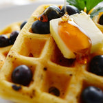 Golden waffle topped with a perfect butter slice, fresh blueberries, and maple syrup—portion cut with a Japanese butter slicer for a flawless finish.
