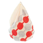 Furoshiki cloth tied into a traditional Japanese bag style, featuring Yumeji Takehisa’s red and grey Tsunagi Dango pattern on cream cotton fabric