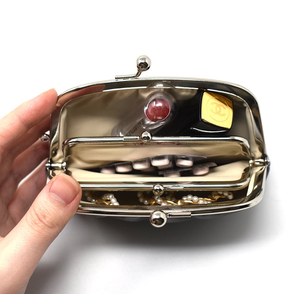 Interior view of the Gamaguchi purse filled with lipstick, compact, pills, and accessories—showcasing its roomy compartments and smart organization.