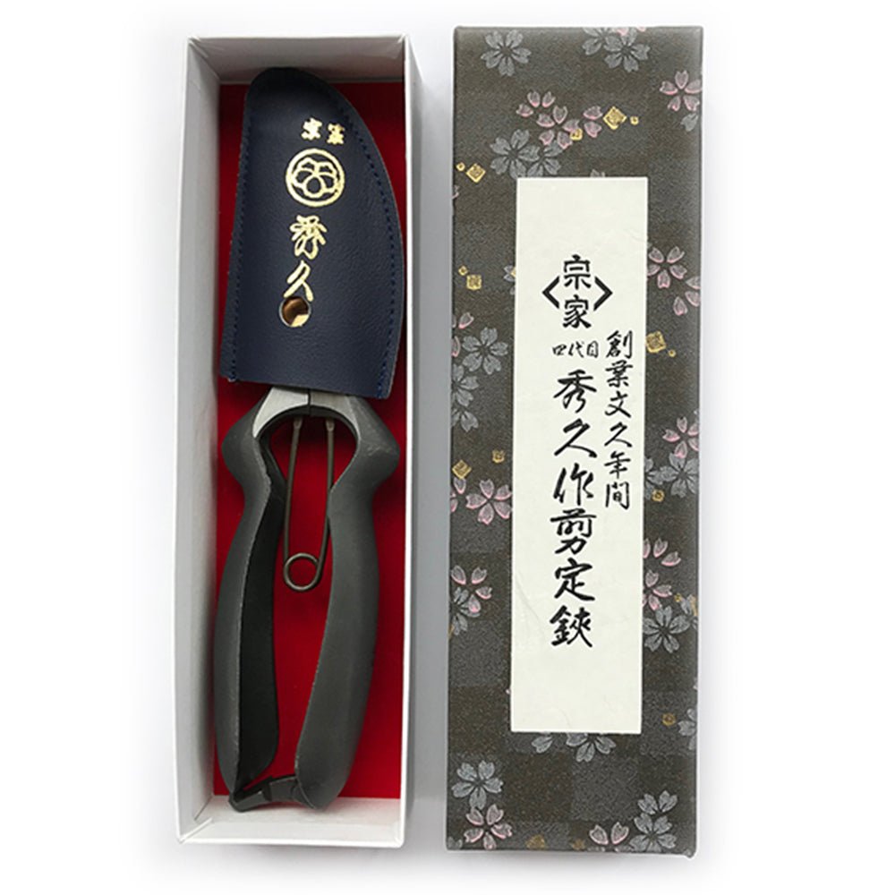 Hidehisa Japanese garden pruners with curved black handles, navy blue leather sheath, and decorative floral-patterned gift box featuring kanji calligraphy