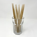 A bundle of natural bamboo chopsticks neatly displayed in a clear glass cup on a white background, showcasing their polished square design and eco-friendly appeal — ideal for minimalist kitchens and traditional Japanese table settings. 