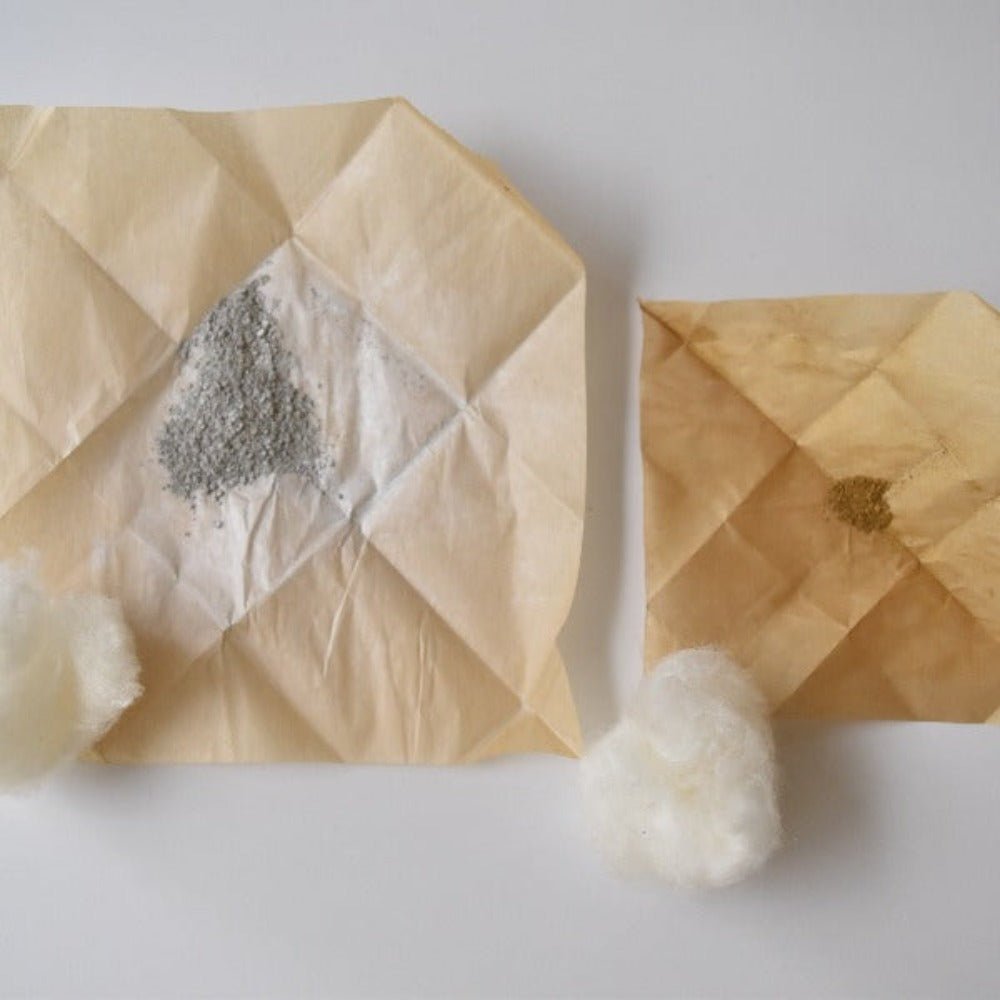 Traditional Japanese Kintsugi repair materials laid out on washi paper, including fine repair powder and silk cotton.