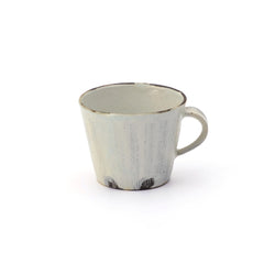 andcrafted Shigaraki pottery mug in kohiki white glaze, featuring soft vertical brushstroke texture and natural dark clay accents at the base. This artisan Japanese mug blends rustic charm with refined simplicity, ideal for enjoying tea or coffee in a serene, minimalist setting.
