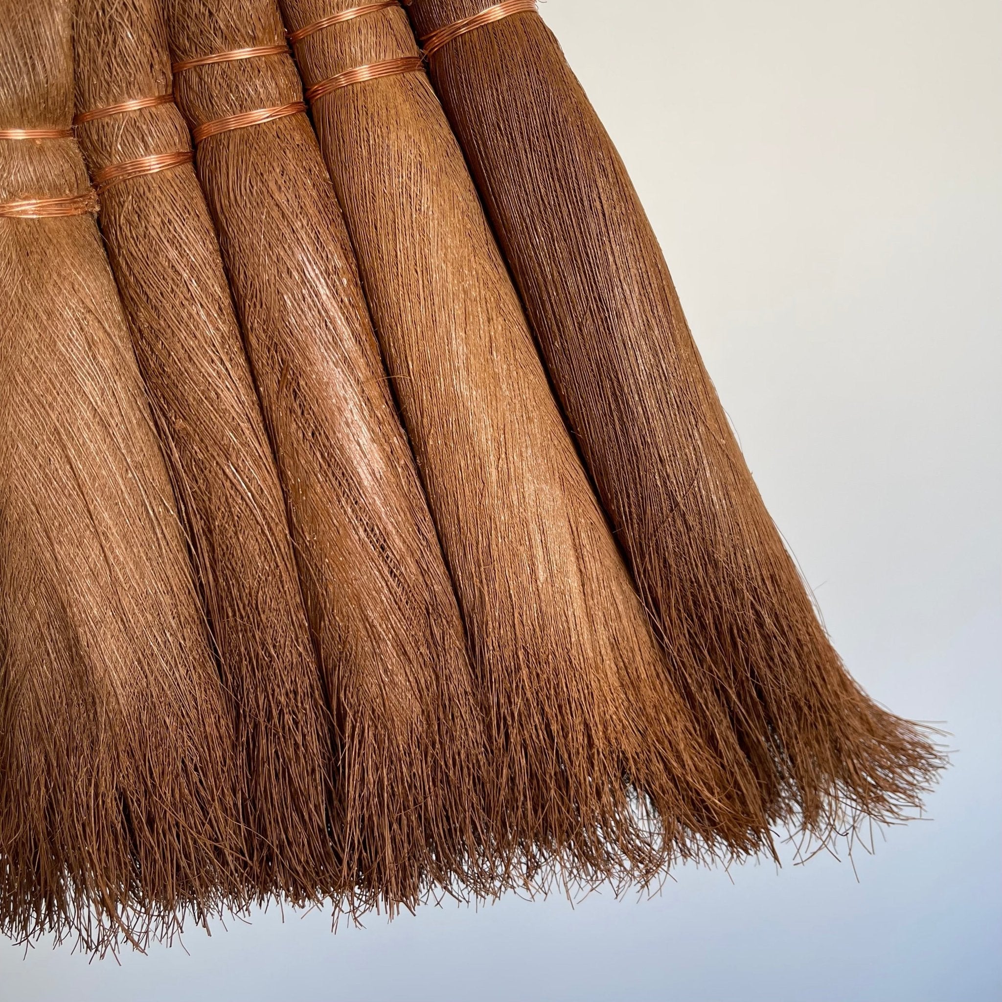 close-up of the bristles of a handcrafted Japanese Shuro angle broom, showcasing the natural texture and fine detail of the palm fibers bound with copper wire. The tightly bundled bristles are soft yet sturdy, ideal for sweeping dust and debris without scratching floors