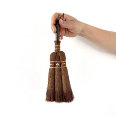 medium Japanese hand broom made from natural palm fibers, held by hand with copper wire detailing for precision cleaning.
