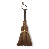 Compact Japanese shuro whisk broom in small size, featuring a dark wooden handle, copper wire binding, and brass fastener, ideal for desktop or narrow surface cleaning.
