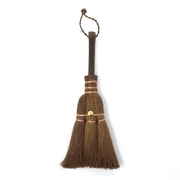 Compact Japanese shuro whisk broom in small size, featuring a dark wooden handle, copper wire binding, and brass fastener, ideal for desktop or narrow surface cleaning.