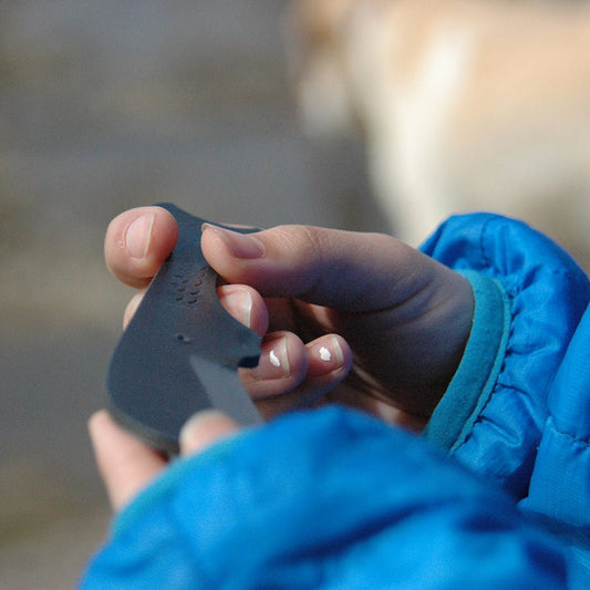 Close-up of a person holding the Sperm Whale Kujira knife outdoors, showcasing the rounded blade tip and compact Japanese craftsmanship in hand